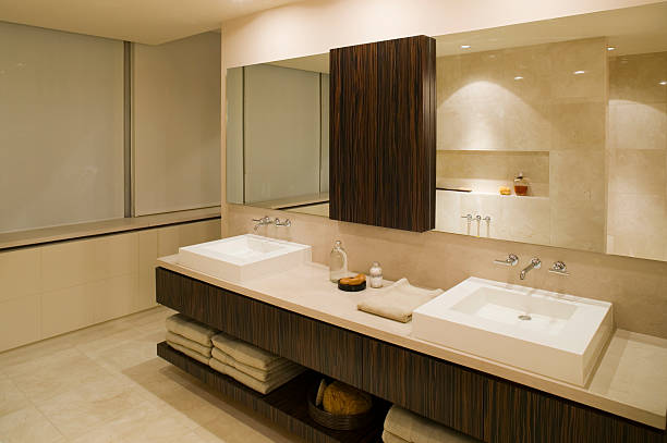 Close up of double bathroom sink with big mirror above it standing in stylish room with dark wooden walls. 3d rendering