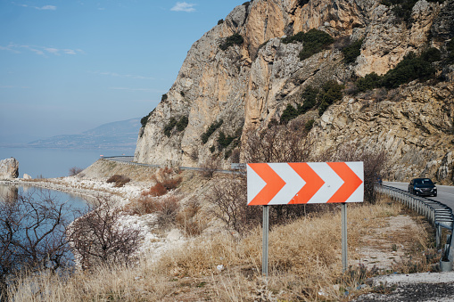 sharp turn road sign on a serpentine road in the mountains