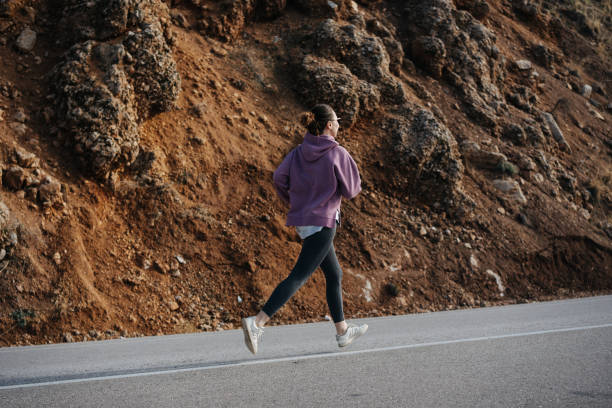 istock Runner on the road uphill against the backdrop of rocks 1729804715