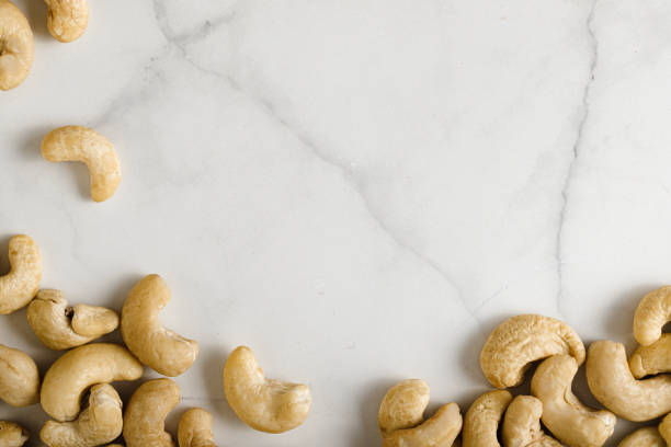 Top view of cashew nuts spilled on marble surface. Cashew nuts on marble table top.