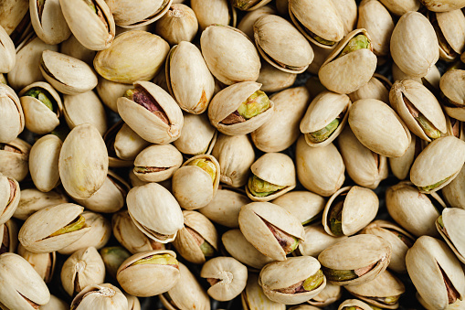 Full frame of pistachio with shells background. Table top view of salted pistachios.