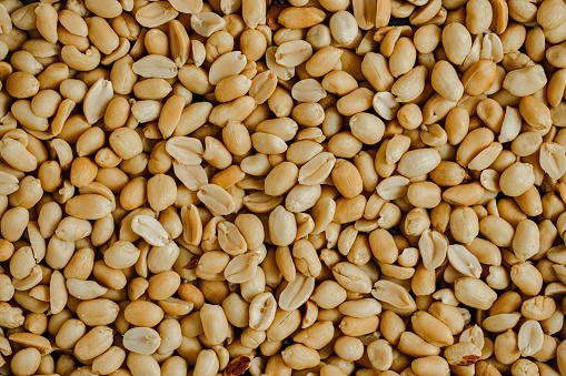 Full frame of crunchy roasted peanuts. Peanuts forming a textured pattern background.