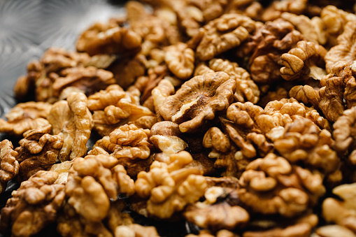 Full frame of peeled walnuts. Close-up view of shelled walnuts with detailed textures and varying shades of brown, suitable for food and nutrition themes.