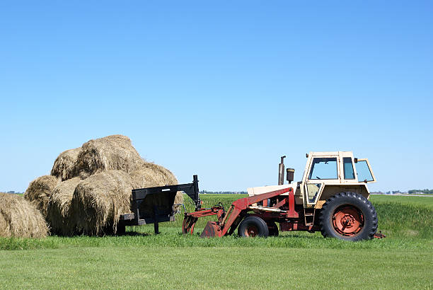 istock farm tractor and load of straw bales 172980745