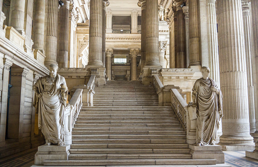 This photo unveils the opulence found within the Brussels Palace of Justice in Belgium. It features a grand interior view showcasing ornate staircases and statues that exude timeless elegance and architectural grandeur. The interior of this iconic neoclassical building is a testament to the artistic and historic significance of this judicial institution.