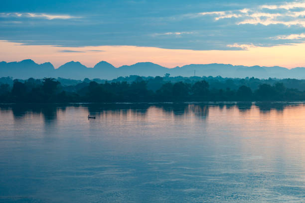 sagome di barche da pesca sul fiume mekong che separa il confine tra thailandia e laos al mattino. lo sfondo sono le montagne. c'è una leggera luce solare. colore giallo chiaro, guarda il paesaggio - computer key internet cafe coffee internet foto e immagini stock