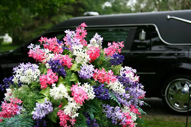 Funeral hearse against a brilliant flower arrangement.