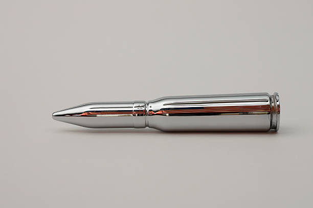Chrome bullet with US Flag reflection 20mm Chrome bullet with a reflection of the United States flag on a light grey background Silver Bullet stock pictures, royalty-free photos & images