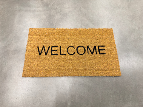 Welcoming floor mat on concrete floor