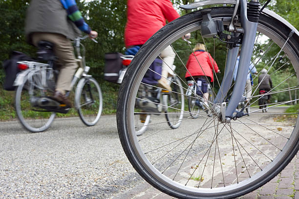 Wurzburg, Germany, May 27th, 2023. Rear view of bicycle with basket on gravel path rests on a sunny gravel path with a backdrop of green fields