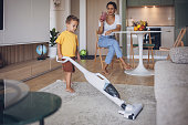 Boy helping mom vacuuming