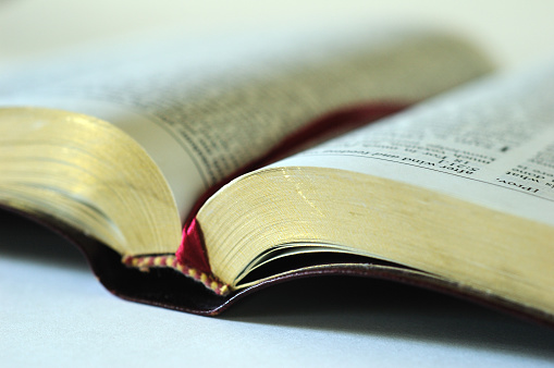 Selective focus view of an open Bible on a table.