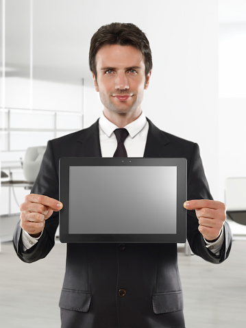 businessman holding a digital computer in an office