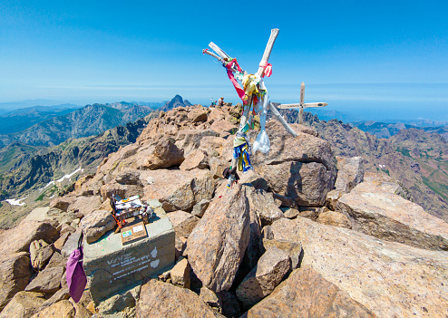 Corse, France - 27 June 2023 - Corsica is a big marine french island in Mediterranean Sea, with hights mountains. Here a view Monte Cinto peak of island, 2706 meters, with the famous GR20 path and the peak with cross.