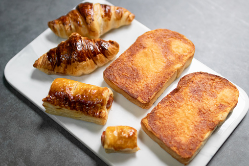 Sizzler bread crispy cheese bread, puff pastry and croissant serving on marble tray.