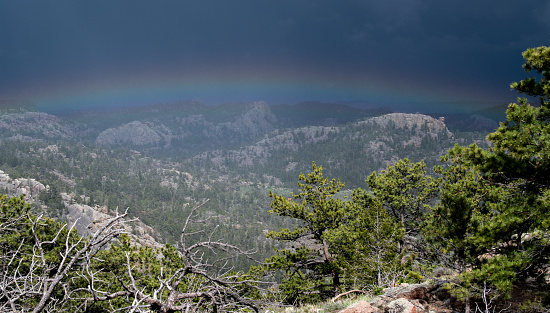 Low horizon rainbow in approaching thunderstorm, Colorado Front Range / Rocky Mountains