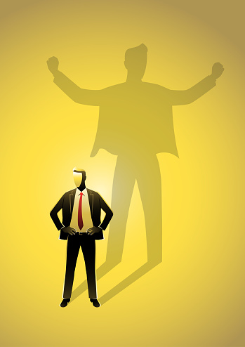 An illustration of businessman standing and casting a shadow of a strong superhero