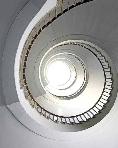 istock spiral staircase going up vertically without people and white light at the top 1729853870
