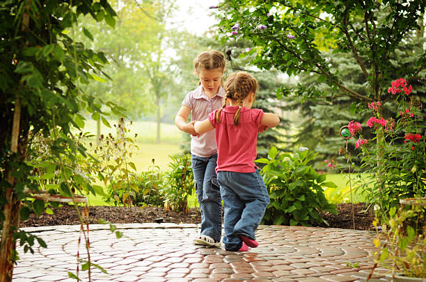dos niñas jugando anillo de la rosas - child dancing preschooler outdoors fotografías e imágenes de stock