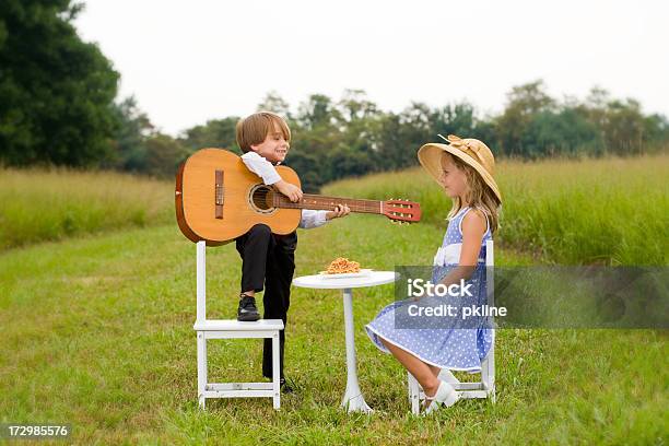 少年と少女のギター Serenades テーブルに座る - ギターのストックフォトや画像を多数ご用意 - ギター, 女の子, 2人