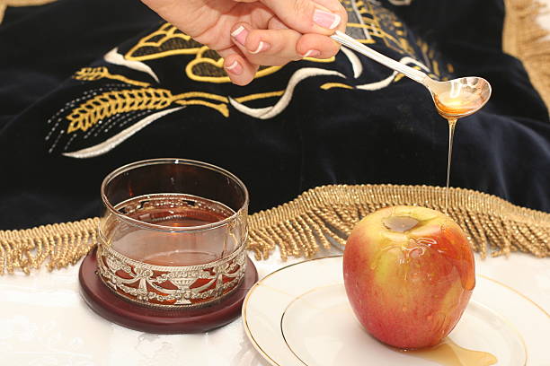 Whole apple on a plate drizzled with honey from a glass stock photo