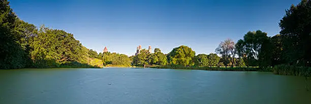 "Clear blue daybreak skies over the green trees of Central Park, the placid waters of the Turtle Pond and the baseball diamonds of the Great Lawn overlooked by the towers of the American Museum of Natural History in the Upper West Side of Manhattan. ProPhoto RGB profile for maximum color fidelity and gamut."