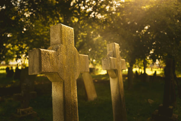 istock Heavenly light seen piercing a tree canopy creating a surreal glow on a pair of ancient stone work crosses. 1729857831