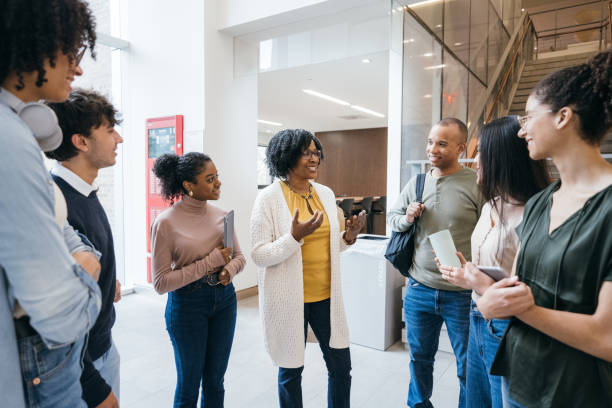 istock Teacher talks to students in University lobby 1729858898