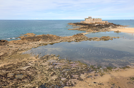 islet on the coast and the sea in France near the city of Saint Malo