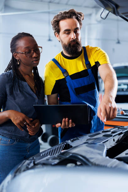 istock Worker informs woman of car motor costs 1729875414