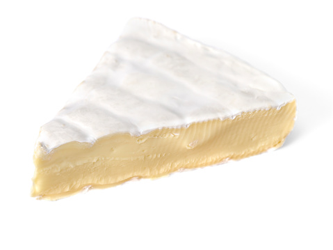 Slice of brie cheese on white background