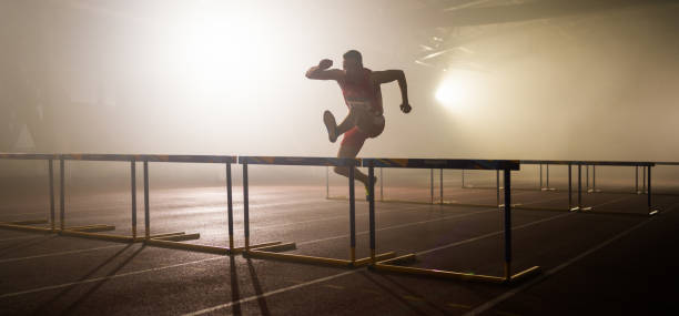 istock Male Runner Training And Jumping Over Hurdles 1729884731