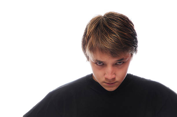 Closeup studio portrait of a 12 year old boy on a beige background