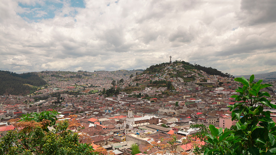 Quito, Pichincha / Ecuador - September 30 2023: Panoramic view of the historic center of the city of Quito with El Panecillo on the horizon during a cloudy day