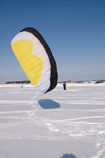 A woman launches her kite on Great Slave Lake in the arctic.  Click to view similar images.