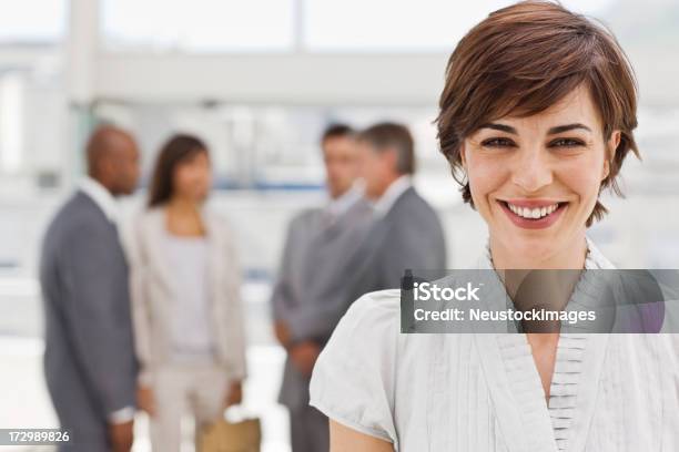 Happy Businesswoman With Colleagues In The Background Stock Photo - Download Image Now