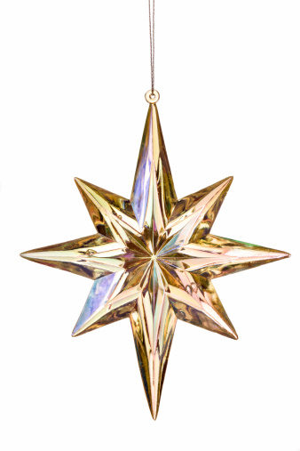 A multi-colored star ornament hangs in front of a solid white background.