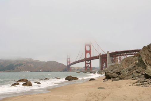Golden Gate Bridge shrouded in fog.  View from North Baker Beach in Golden Gate National Recreation Area.