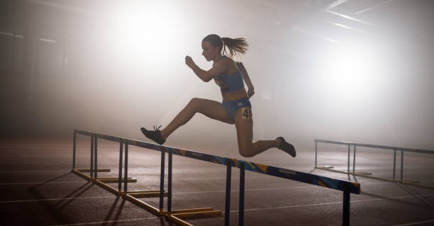 istock Female Runner Training And Jumping Over Hurdles 1729909532
