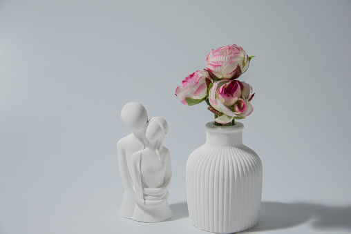 Small white ceramic vase - figurine of human couple. handmade symbolic ceramic figurines on white background