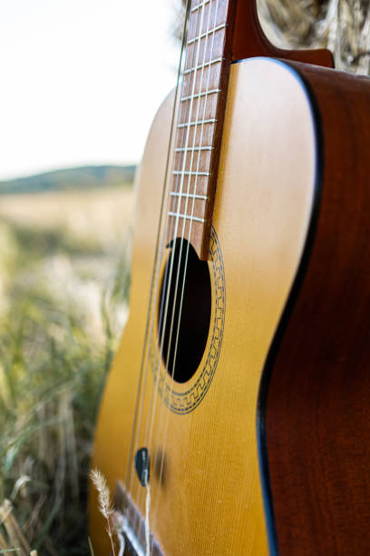 istock Close up of an acoustic guitar leaning on haystack. 1729918458