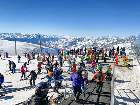 Skiers at Klein Matterhorn mountain peak (3,883 m) at Zermatt ski resort, Valais canton, Switzerland, in winter. VIew towards Italy, Cervinia ski resort.