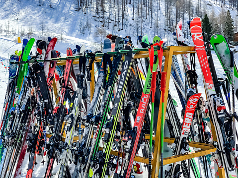 Skis and ski poles put in rack at slope of ski resort Cervinia, Italy.
