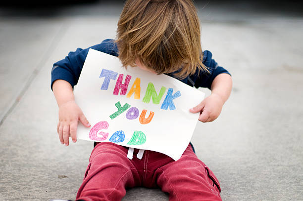 Thank you God Little boy holding a Thank you God sign- focus on the boy's hair. praying child religion god stock pictures, royalty-free photos & images