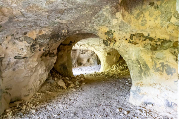 istock Tunnels inside an empty cave, walls with uneven texture and cracks 1729932054