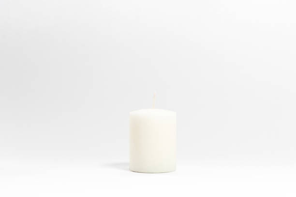 istock A small white candle isolated on a white background. 1729932694