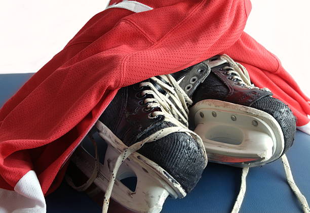 Hockey Skates and Red Jersey Well worn professional hockey skates and jersey red hockey jersey stock pictures, royalty-free photos & images
