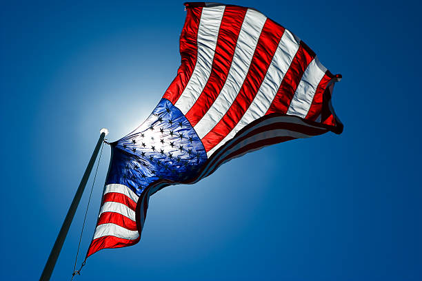 American flag st against sky and sun background. Motion blur and sunlight directly behind flag.More Flags: