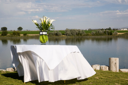 Decorated event table with the cloth blowing in the breeze.