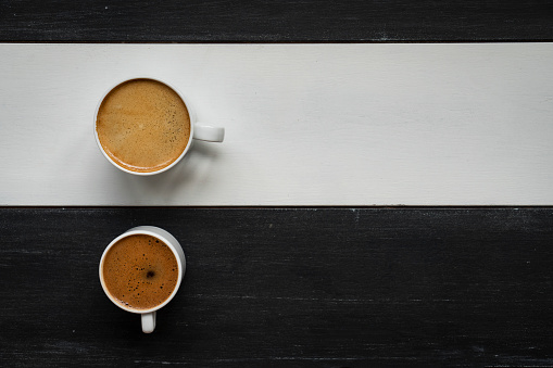 Two coffee cups on wooden